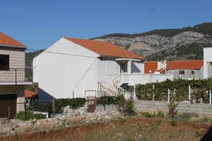 een wit huis met een heuvel op de achtergrond bij Apartments with a parking space Komiza, Vis - 8866 in Komiža +14 foto's