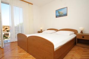 a bedroom with a large bed with white sheets at Apartments with a parking space Komiza, Vis - 8866 in Komiža