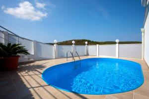 a large blue pool on a balcony with at Luxury villa with a swimming pool Vis - 8922 in Vis