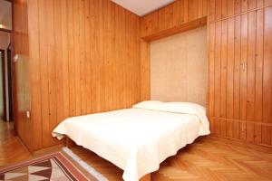 a bedroom with a bed in a wooden wall at Apartments by the sea Vis - 8875 in Vis