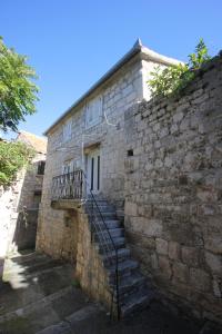 ein Steingebäude mit einer Treppe, die zu einer Tür führt in der Unterkunft Apartments by the sea Vis - 8932 in Vis