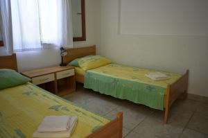 a bedroom with two beds and a desk and a mirror at Apartments by the sea Milna, Vis - 8943 in Rukavac