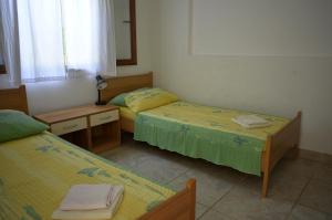 sypialnia z 2 łóżkami, biurkiem i lustrem w obiekcie Apartments by the sea Milna, Vis - 8943 w mieście Rukavac