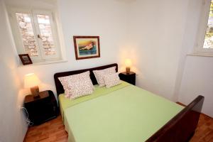 ein Schlafzimmer mit einem grünen Bett mit zwei Kissen in der Unterkunft Apartments by the sea Vis - 8932 in Vis