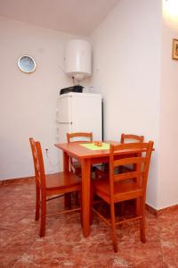 eine Küche mit einem Tisch und Stühlen sowie einem Kühlschrank in der Unterkunft Apartments by the sea Vis - 8932 in Vis