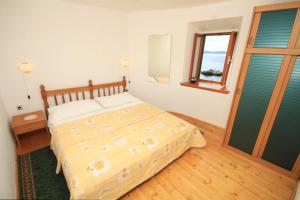 Schlafzimmer mit einem Bett und einem Fenster in der Unterkunft Apartments and rooms by the sea Komiza, Vis - 8910 in Komiža