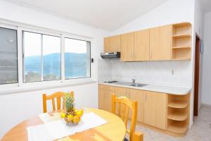 a kitchen with a wooden table and a table and chairs at Apartments by the sea Marina, Trogir - 9037 in Marina