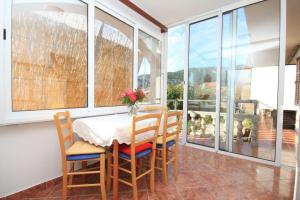 a dining room with a table and chairs and windows at Apartments with WiFi Komiza, Vis - 8911 in Komiža