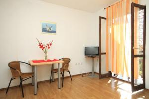 um quarto com uma mesa e cadeiras e uma televisão em Apartments with WiFi Komiza, Vis - 8911 em Komiža