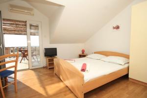 um quarto com uma cama, uma secretária e uma televisão em Apartments with WiFi Komiza, Vis - 8911 em Komiža