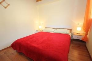 un letto rosso in una camera bianca con due lampade di Apartments with WiFi Vis - 8872 a Vis