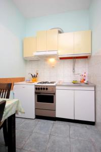 una cucina con armadi bianchi e piano cottura di Apartments with WiFi Vis - 8872 a Vis
