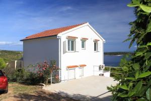 ein kleines weißes Haus mit Blick auf das Wasser in der Unterkunft Apartments with parking spaces Brgujac, Vis - 8919 in Rukavac