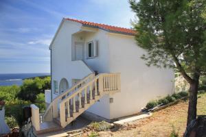 a white house with a staircase next to a tree at Apartments with a parking space Brgujac, Vis - 8919 in Rukavac