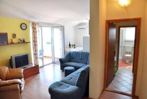 a living room with two blue couches and a television at Apartments with a parking space Brgujac, Vis - 8919 in Rukavac