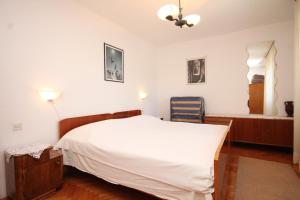 a bedroom with a white bed and a window at Apartments by the sea Milna, Vis - 8913 in Vis