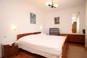 um quarto com uma cama branca e uma janela em Apartments by the sea Milna, Vis - 8913 em Vis