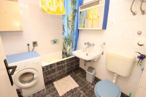 uma casa de banho com um WC, um lavatório e uma máquina de lavar roupa em Apartments by the sea Milna, Vis - 8913 em Vis
