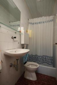 uma casa de banho com um WC, um lavatório e um chuveiro em Apartments by the sea Milna, Vis - 8913 em Vis