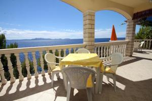 a table and chairs on a porch overlooking the ocean at Apartments by the sea Brna - Vinacac, Korcula - 9152 in Smokvica