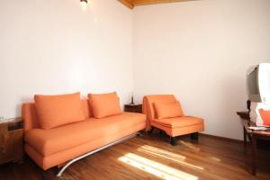 eine orangefarbene Couch und ein Stuhl in einem Zimmer in der Unterkunft Apartments with a parking space Podspilje, Vis - 8915 in Vis
