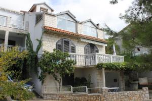 a large white house with a balcony at Apartments by the sea Brna, Korcula - 9149 in Smokvica
