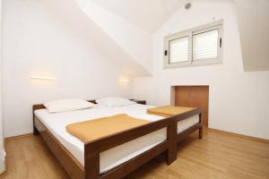 a bedroom with a bed and a window at Apartments by the sea Brna, Korcula - 9149 in Smokvica