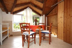 a dining room with a table and chairs and a window at Apartments by the sea Brna, Korcula - 9149 in Smokvica