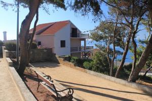 a park bench sitting in front of a house at Apartments by the sea Zavalatica, Korcula - 9137 in Zavalatica