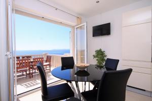 a dining room with a table and chairs and a balcony at Apartments by the sea Zavalatica, Korcula - 9138 in Zavalatica