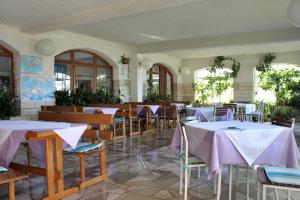 restauracja ze stołami i krzesłami z fioletową tkaniną w obiekcie Apartments and rooms with parking space Makarska - 9128 w Makarskiej