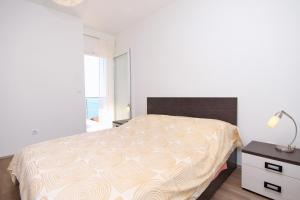 a bedroom with a bed and a lamp and a window at Apartments by the sea Zavalatica, Korcula - 9138 in Zavalatica