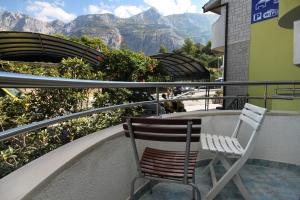 stół i krzesła na balkonie z widokiem na góry w obiekcie Apartments and rooms with parking space Makarska - 9128 w Makarskiej