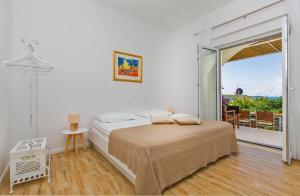 een witte slaapkamer met een bed en een balkon bij Apartments with a parking space Mlini, Dubrovnik - 9043 in Mlini