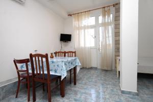 jadalnia ze stołem, krzesłami i telewizorem w obiekcie Apartments and rooms with parking space Makarska - 9128 w Makarskiej