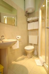 een badkamer met een toilet, een wastafel en een spiegel bij Apartments with a parking space Mlini, Dubrovnik - 9043 in Mlini