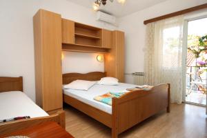 sypialnia z 2 łóżkami i dużym oknem w obiekcie Apartments and rooms with parking space Makarska - 9128 w Makarskiej