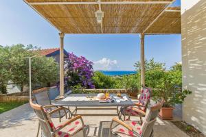 een tafel en stoelen op een patio met uitzicht op de oceaan bij Apartments with a parking space Mlini, Dubrovnik - 9043 in Mlini