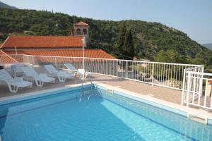a large swimming pool with chairs at Holiday house with a swimming pool Dubravka, Dubrovnik - 9101 in Gruda