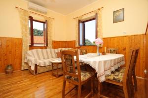 a dining room with a table and chairs in a room at Holiday house with a swimming pool Dubravka, Dubrovnik - 9101 in Gruda