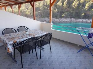 a table and chairs with a view of the water at Apartments by the sea Cove Mala Pogorila, Hvar - 8952 in Bogomolje