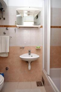 Apartments by the sea Brna, Korcula - 9139 في برنا: حمام مع حوض ومرحاض ومرآة