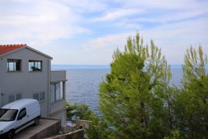 a white van parked next to a house and the ocean at Apartments by the sea Prigradica, Korcula - 9141 in Blato