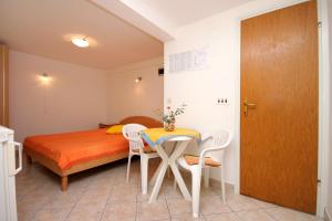 a bedroom with a bed and a table and chairs at Apartments by the sea Prigradica, Korcula - 9141 in Blato