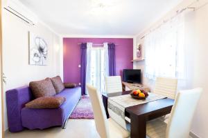 een woonkamer met een paarse bank en een tafel bij Apartments by the sea Brna, Korcula - 9147 in Brna