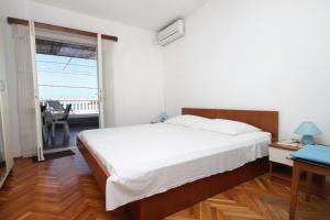 a bedroom with a large bed and a balcony at Apartments and rooms by the sea Molunat, Dubrovnik - 8964 in Gruda