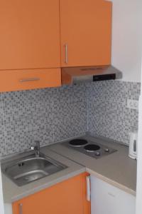 a kitchen with orange cabinets and a sink at Apartments and rooms by the sea Molunat, Dubrovnik - 8964 in Gruda