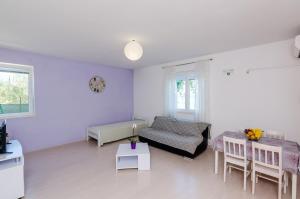 a white living room with a couch and a table at Apartments by the sea Sladjenovici, Dubrovnik - 9012 in Slano