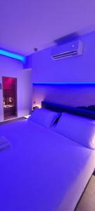 1 Schlafzimmer mit 2 Betten und violetten Lichtern in der Unterkunft Piccolo Feudo Green Resort in Viterbo