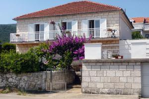 a house with purple flowers in front of it at Family friendly apartments with a swimming pool Kneza, Korcula - 9130 in Račišće